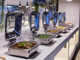 Una barra de buffet con diferentes opciones de comida y un espejo decorativo.