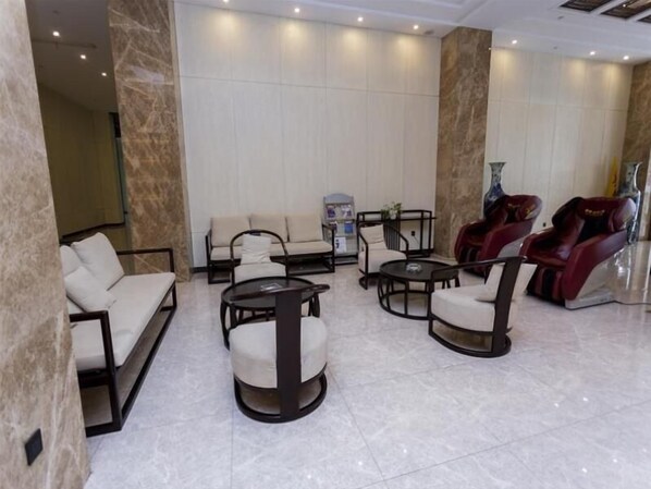 A spacious lobby with a marble floor, a sofa, two armchairs, a coffee table, and a massage chair. - Greentree Eastern Tongcheng Economic Development Zone Tianhong Hotel (Tongcheng)