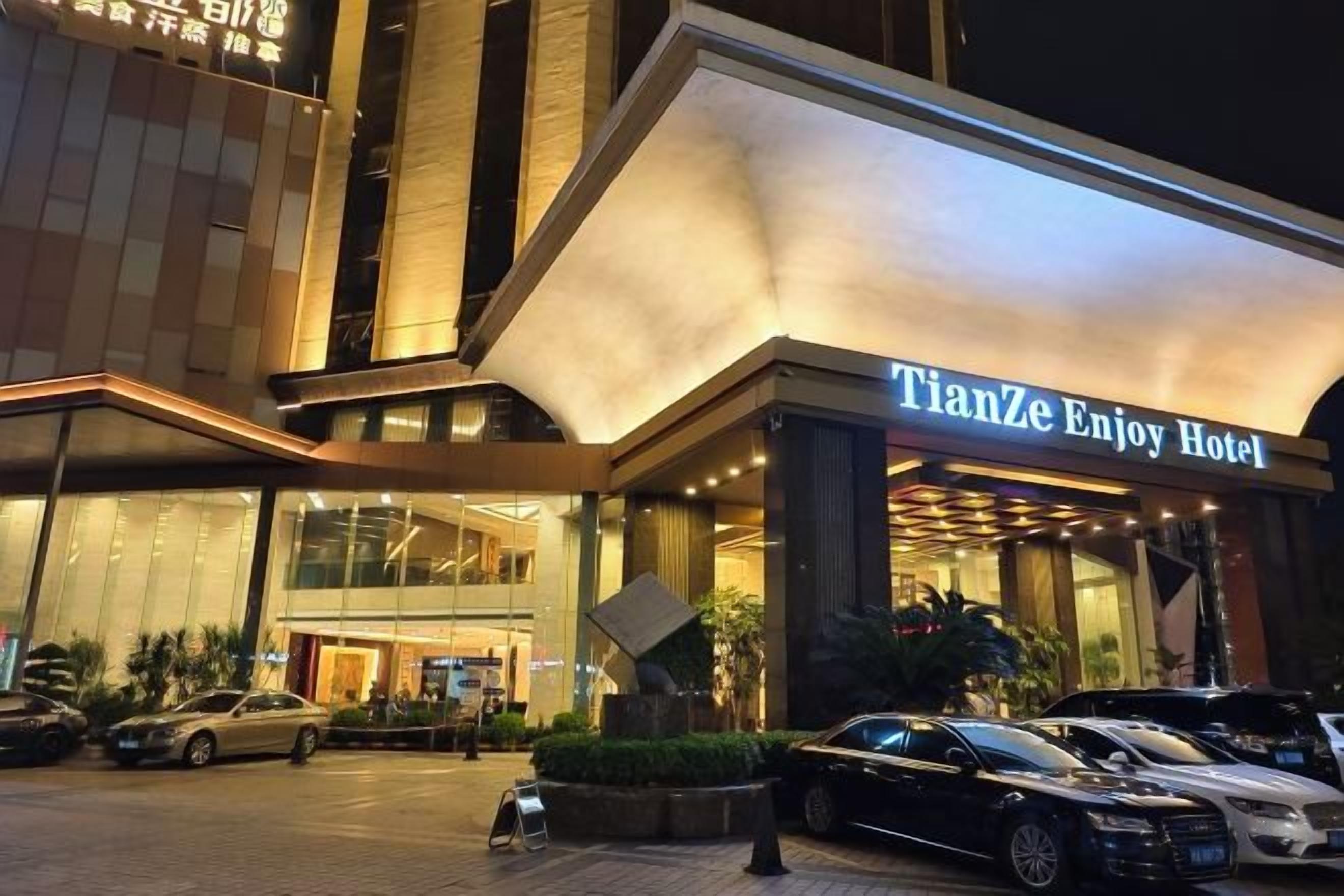 L’entrée d’un hôtel, avec une enseigne indiquant : « TianZe Enjoy Hotel ».