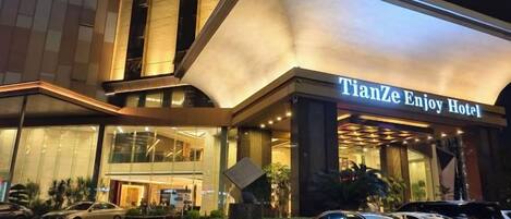 L’entrée d’un hôtel, avec une enseigne indiquant : « TianZe Enjoy Hotel ».