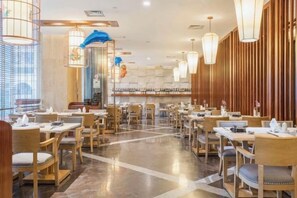A spacious restaurant with multiple tables and chairs, a polished floor, and a modern interior design. - Tianze Enjoy Hotel (Fuqing)