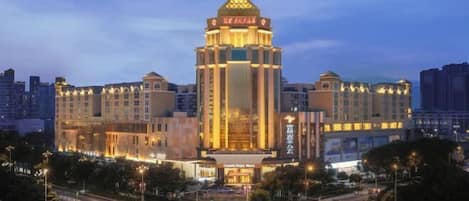 Un hotel con una torre destacada, varios pisos y una fachada bien iluminada.