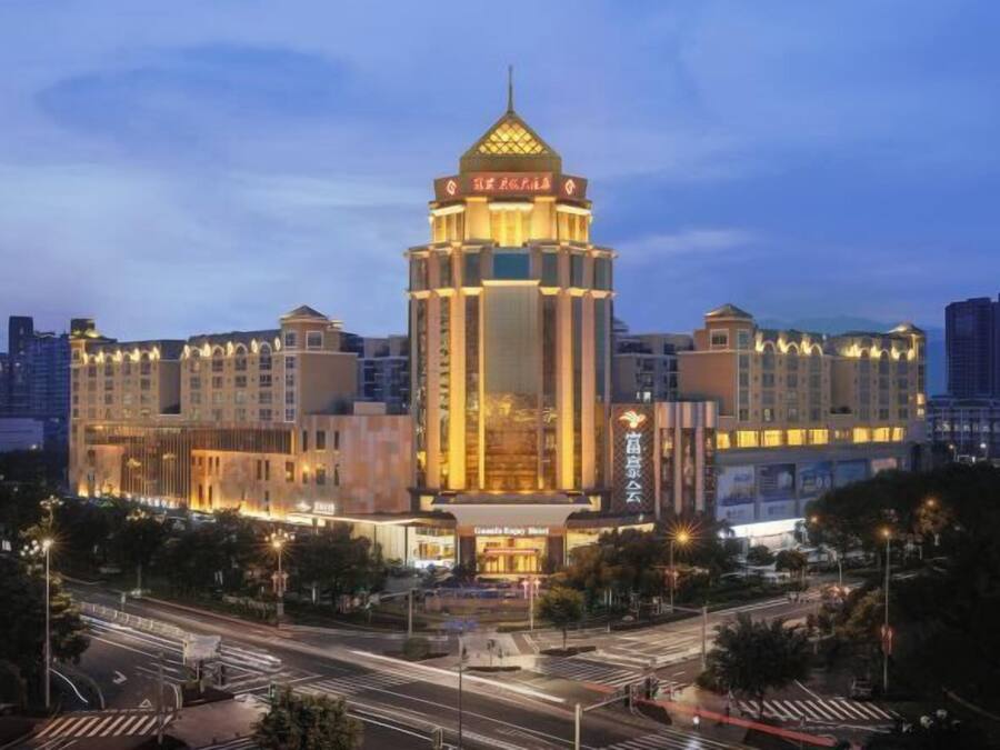 A hotel with a prominent tower, multiple floors, and a well-lit facade.