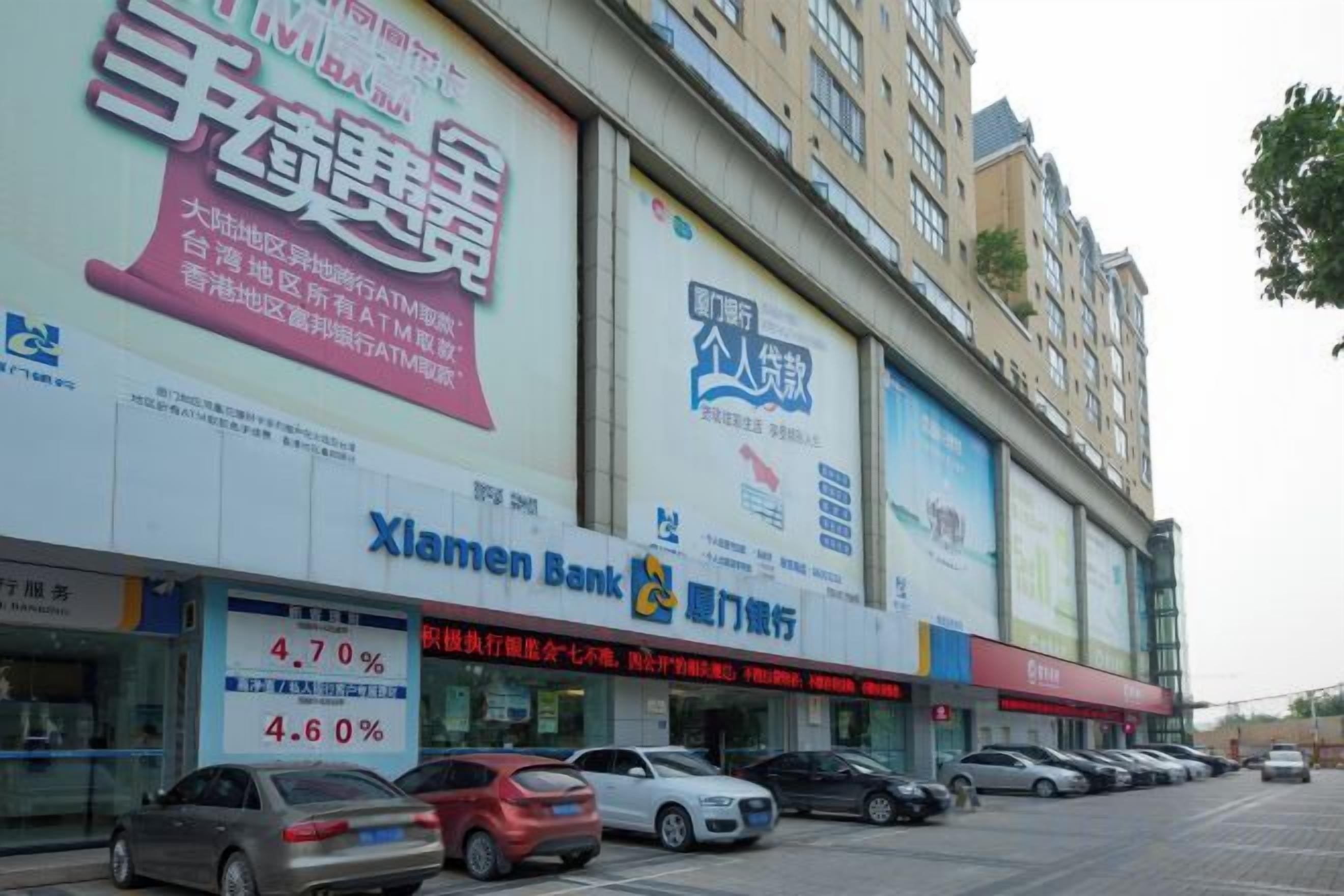 Un edificio comercial con varias fachadas, incluyendo un banco y una agencia de automóviles.