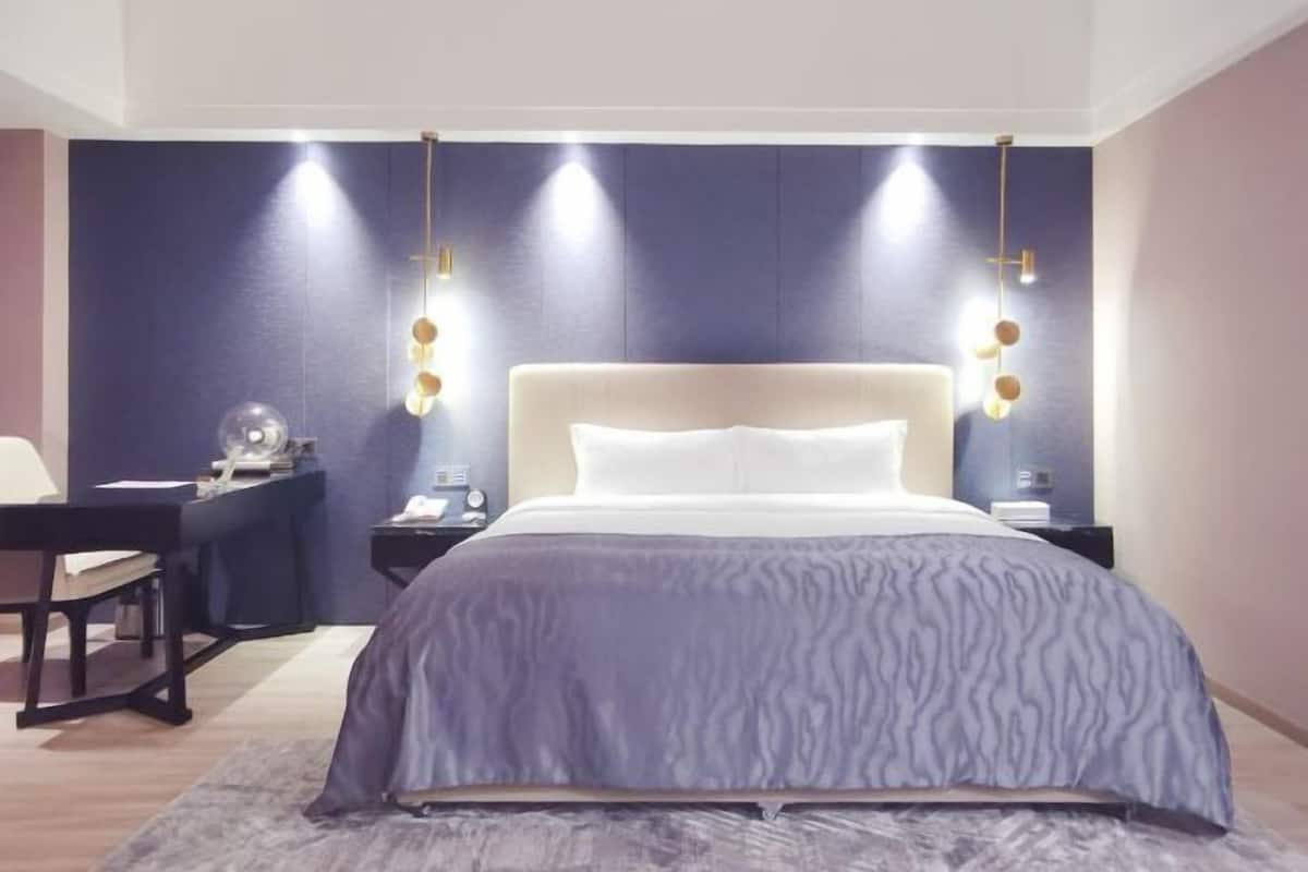 Une chambre à coucher moderne, avec un lit, des tables de chevet, un bureau et une chaise.