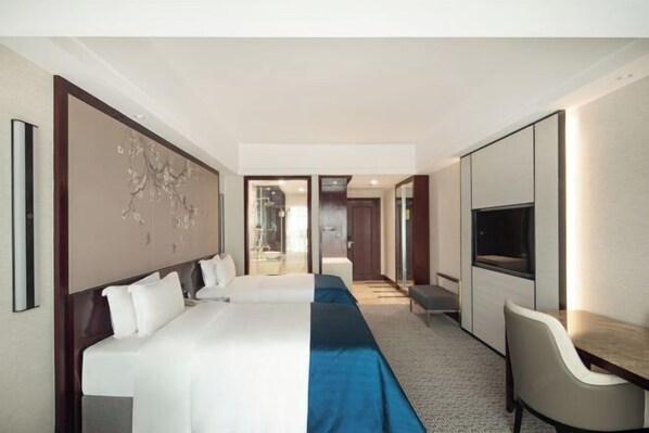 A hotel room with a large bed, a desk, a chair, and a TV. - Tianze Enjoy Hotel (Fuqing)