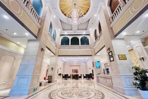 A grand lobby with a high ceiling, a central chandelier, and a symmetrical floor design. - Vienna Hotel (Yingcheng Railway Station Haishan) (Yingcheng)