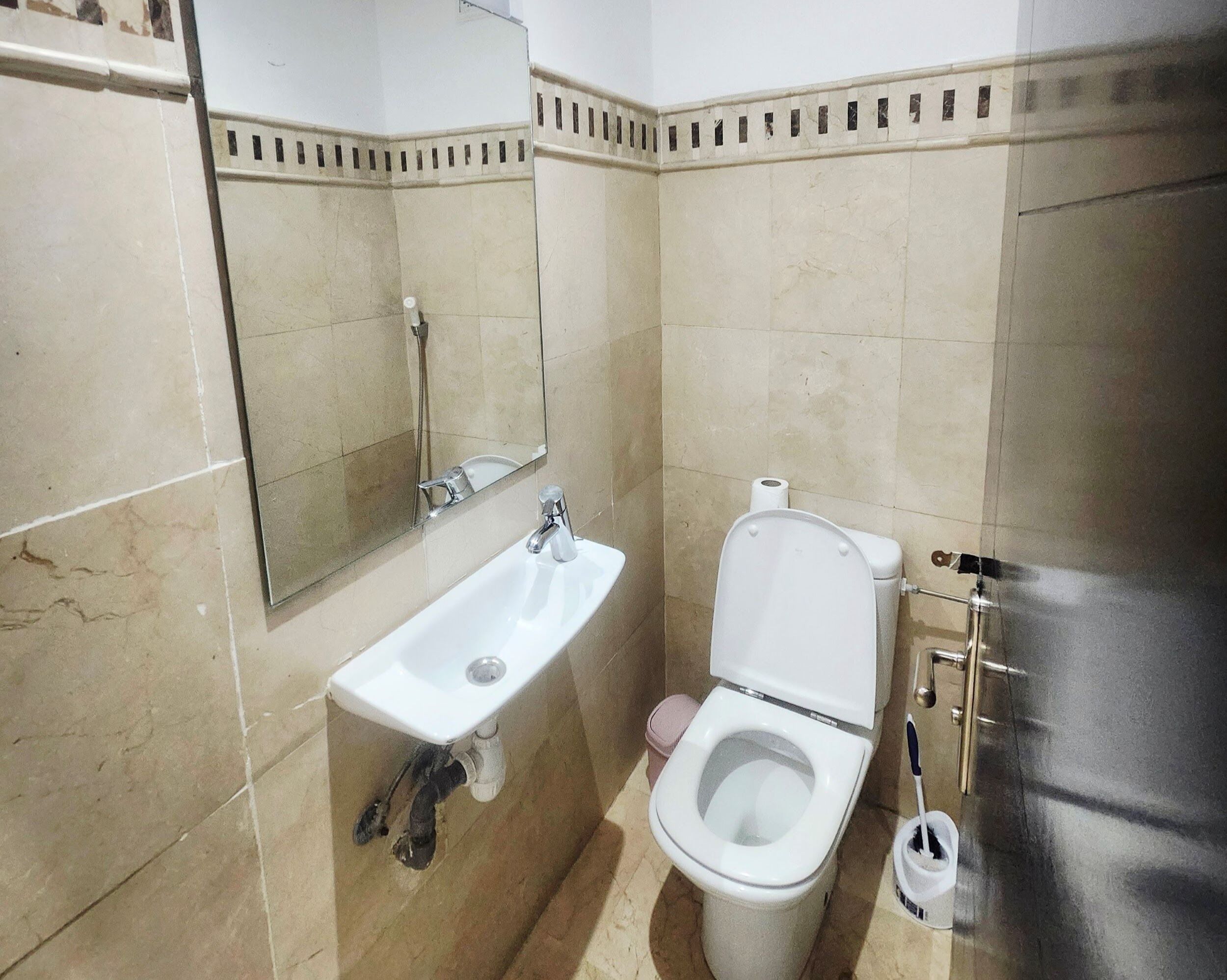 Une salle de bain avec un lavabo, des toilettes et un miroir.