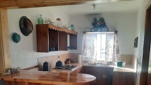 Una cocina con una isla de madera, taburetes, un fregadero y armarios.