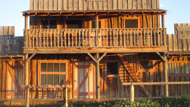 Un edificio de madera con un balcón, identificado como 
