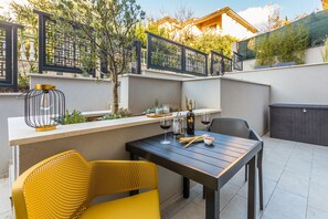 An outdoor patio with a table set for dining, chairs, and a decorative lamp.