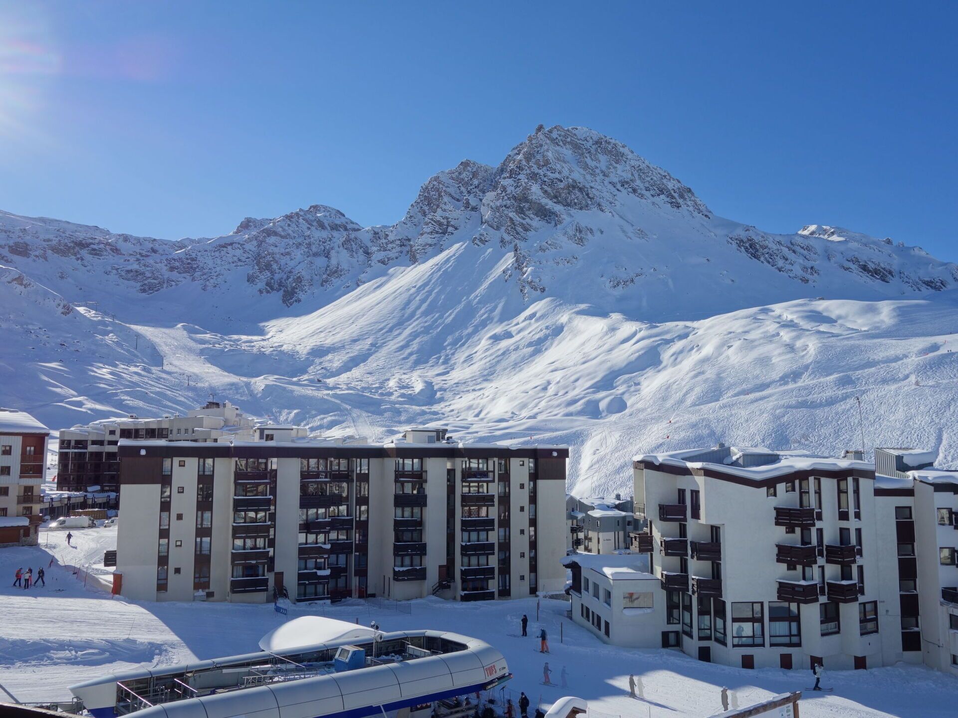 Una montagna innevata con edifici moderni in primo piano.