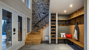 Ein modernes Interieur mit einer Steintreppe, Holzbanken und einer Bank mit rotem Kissen.