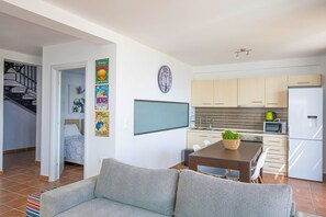 Un appartement moderne comprenant un salon, une cuisine et un escalier menant à une autre pièce.