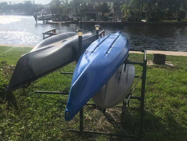 Two kayaks on a rack by a body of water. - Cotee River Tiki Hut (New Port Richey)