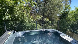 A hot tub surrounded by lush greenery and trees. - TreeTops - wood fire, outdoor spa and great coffee (Hepburn Springs)