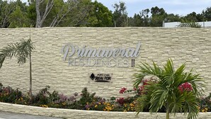 Paredão de pedra com o texto "Primavera Residences II" e uma placa para Punta Cana Real Estate.