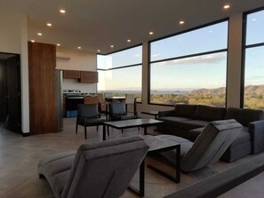Una sala de estar moderna con un ventanal que ofrece vistas del paisaje desértico.