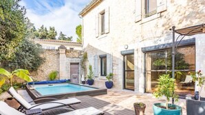 A pool area with lounge chairs, a stone wall, and potted plants. - Le Mas Provençal by Interhome (Jonquieres Saint Vincent)