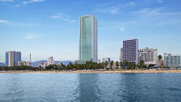A coastal cityscape with high-rise buildings, a beach, and clear skies. - Tony Luxury Apartment - Venue Stay (Nha Trang)