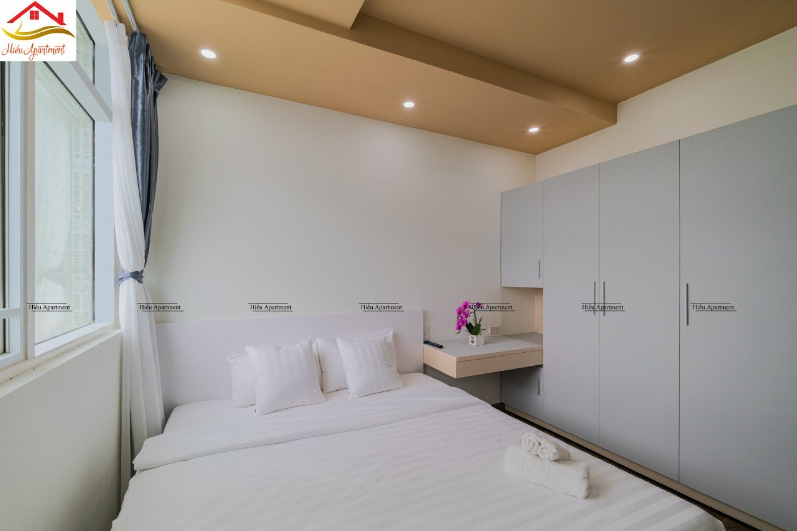 Une chambre à coucher comprenant un lit, une table de chevet, un bureau et une armoire.