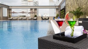 A poolside area with lounge chairs and a bar area with a martini glass and a watermelon slice. - Tony Luxury Apartment - Venue Stay (Nha Trang)
