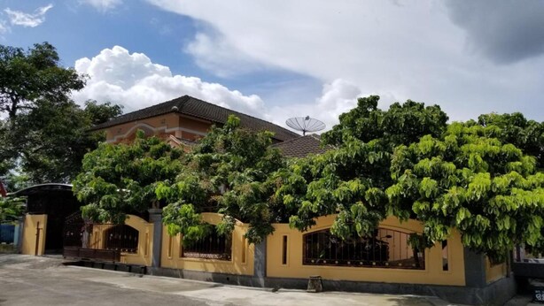 A two-story building with a satellite dish, surrounded by lush greenery. - Algira Homestay Prambanan (Prambanan)