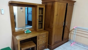 A wooden wardrobe with a mirror and a small desk with drawers. - Algira Homestay Prambanan (Prambanan)