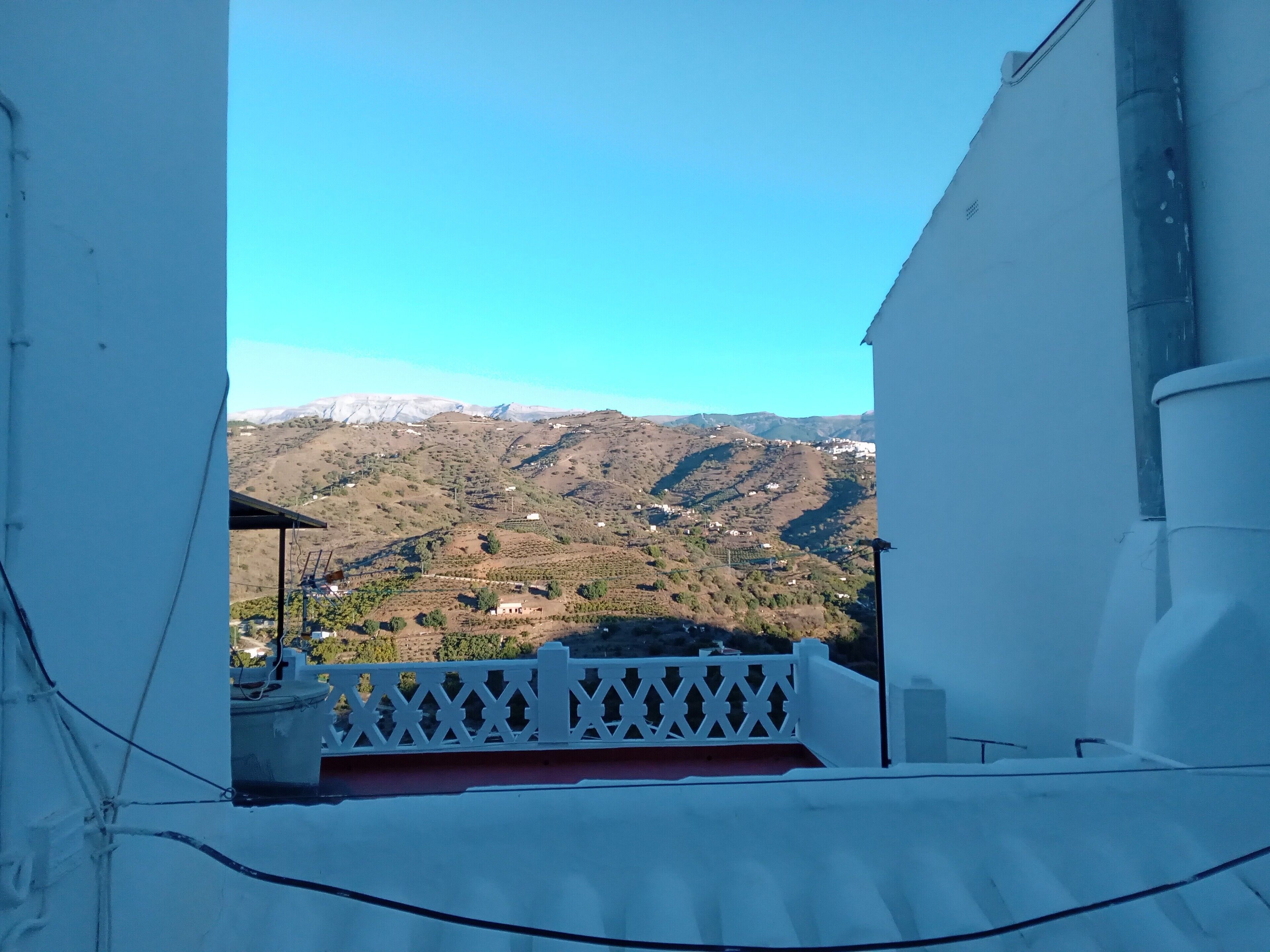 A balcony with a view of a mountainous landscape.