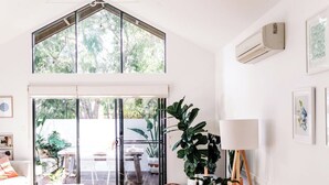 A spacious room with a large window, a ceiling fan, and a sliding glass door leading to an outdoor area. - The Villa | Margaret River (Margaret River)