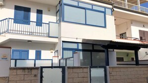 Un edificio de varios pisos con balcones, ventanas grandes y una pared de piedra.