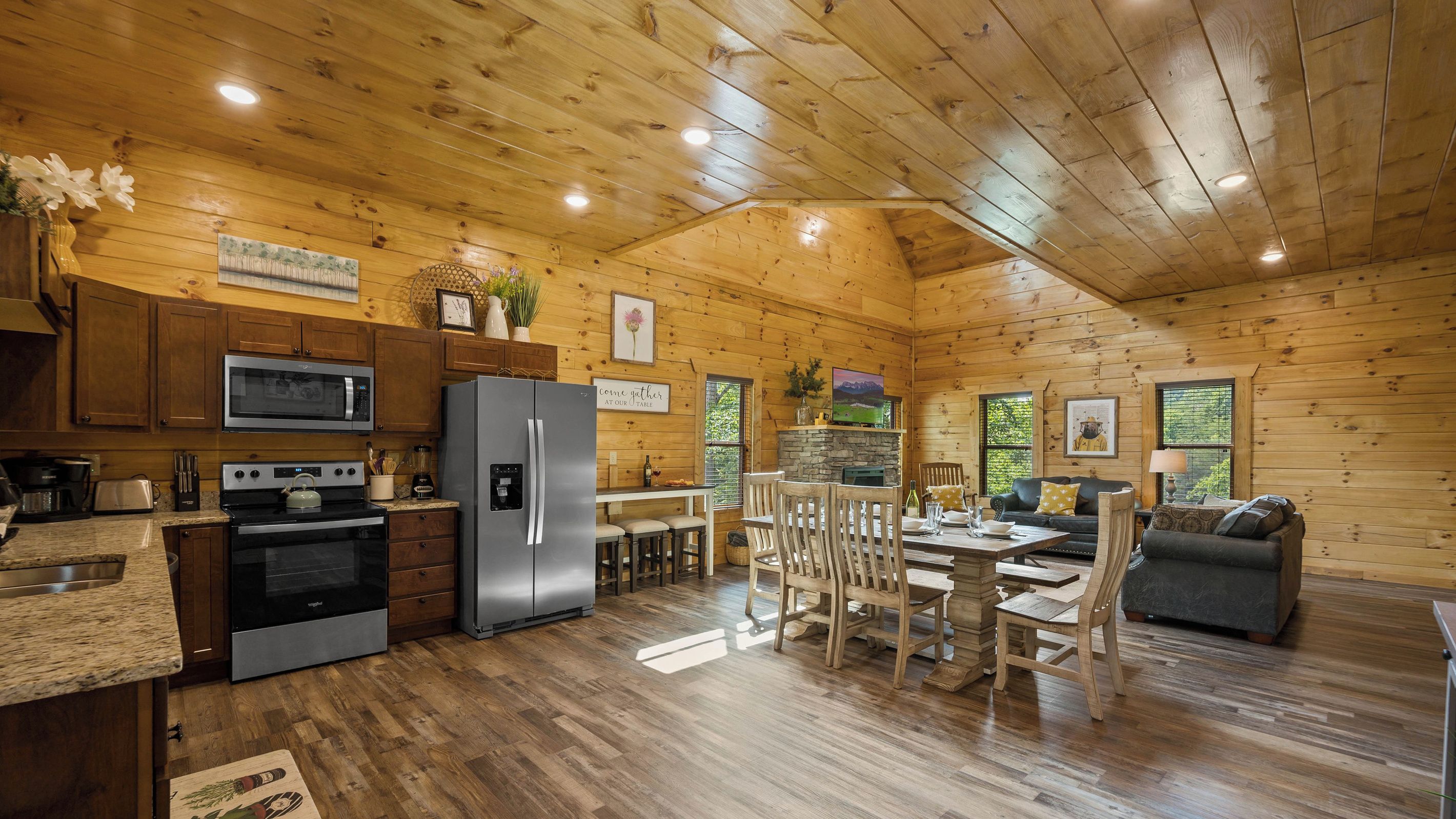 A spacious kitchen with modern appliances, a dining area with wooden furniture, and a cozy living space with a fireplace.