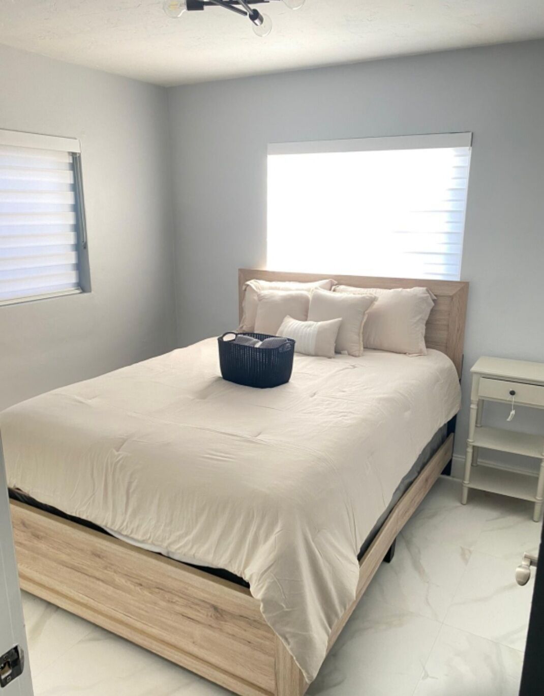 Une chambre à coucher avec un lit, une table de chevet et une fenêtre.