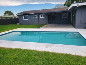 Relax by the pool surrounded by a well-manicured lawn.