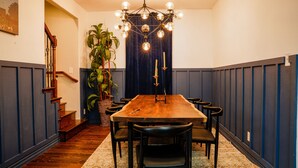 A dining room with a wooden table, black chairs, a chandelier, and a potted plant. - 4 BR , Large Yard with HOT TUB, Fire pit,Basket ball hoop (Dallas)
