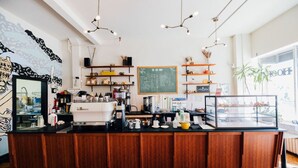 A coffee shop with a wooden counter, shelves with various items, a chalkboard menu, and a display case. - One Of A Kind Huge Loft Minutes From Downtown (Detroit)