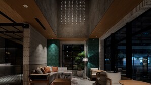Un interior moderno con un sofá, sillas y una mesa. Hay una planta en maceta y una lámpara.