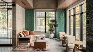 Un interior moderno con un sofá modular, un banco y un comedor con sillas y mesas.