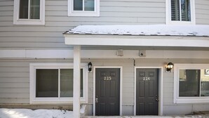 A two-story house with a covered front porch, numbered doors 225 and 226, and a snow-covered roof. - Main Street Snowcave walkable to Quicksilver (Breckenridge)