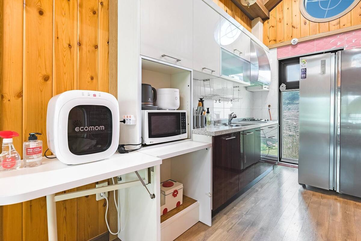 Eine moderne Küche mit Einbauofen, Mikrowelle und Edelstahl-Kühlschrank.