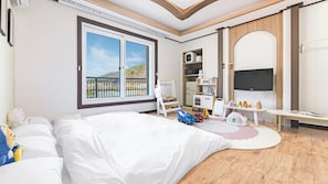 Habitación de hotel con una cama grande, televisión, escritorio y balcón con vistas.