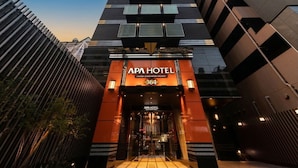 Een moderne hotelentree met een opvallend bord waarop 'APA HOTEL 364' staat.