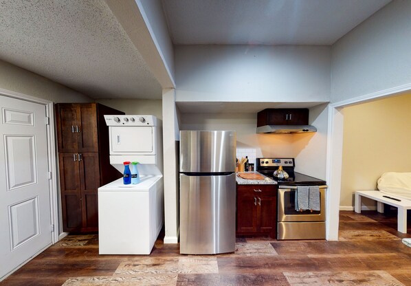 Enjoy meal preparation in this well-lit kitchen with an oven, refrigerator, and seating area.