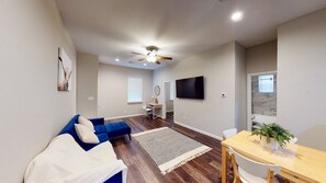 Relax in this inviting living space with a sofa, dining table, and flat-screen TV.