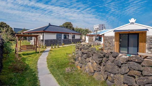 A modern building with a stone wall and a wooden deck.
