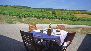 A table set outdoors with a view of vineyards in the background. - Villa in Conilhac with Private Terrace (Conilhac-De-La-Montagne)