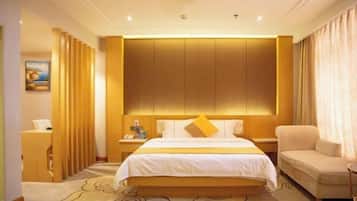 A hotel room with a large bed, a nightstand, a chair, and a desk.