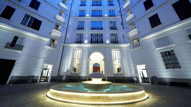 A courtyard with a central fountain, surrounded by multi-story buildings with balconies and large windows. - luxury home in the heart of Napoli historical district (Napoli)