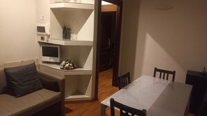 A compact living space with a sofa, a dining table, and a TV. - Stefano House Apartment Trevi Fountain  (Roma)