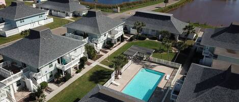 Zona residencial con casas, piscina y un cuerpo de agua.